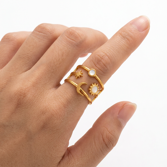 Złoty pierścionek z motywem nieba na dłoni modelki na białym tle