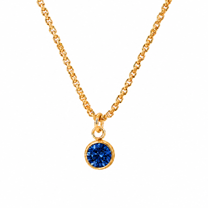 Złoty naszyjnik ze stali nierdzewnej z okrągłą ciemnoniebieską cyrkonią na białym tle