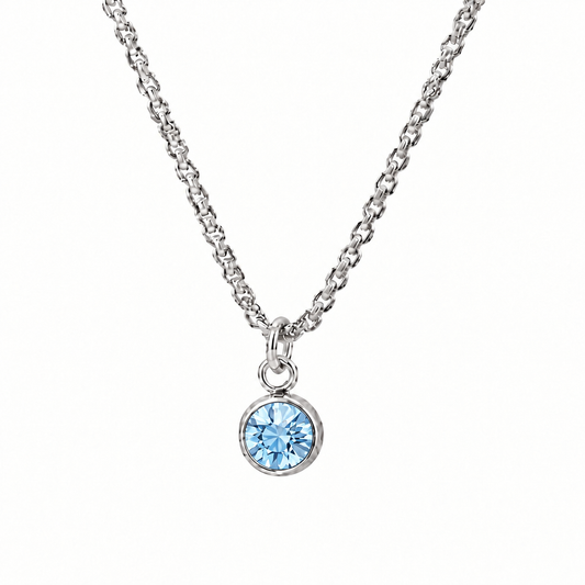 Srebrzysty naszyjnik z okrągłą jasnoniebieską cyrkonią w zbliżeniu na białym tle