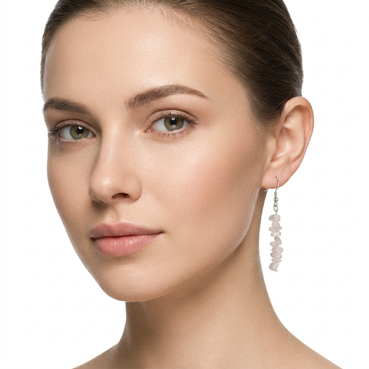 Modelka z wąskim wiszącym kolczykiem z kwarcu różowego na białym tle