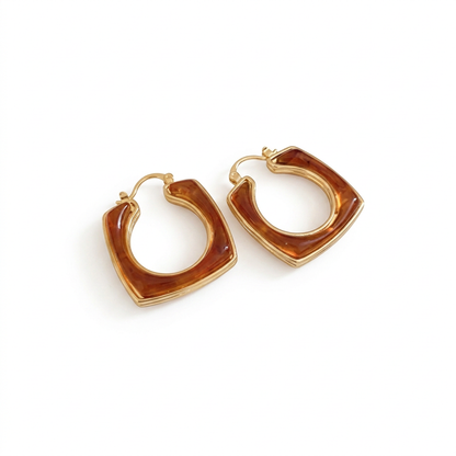 Para brązowych geometrycznych kolczyków z żywicy ze złotą obwódką na białym tle